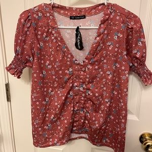 Juniors Medium floral short sleeve dressy top.